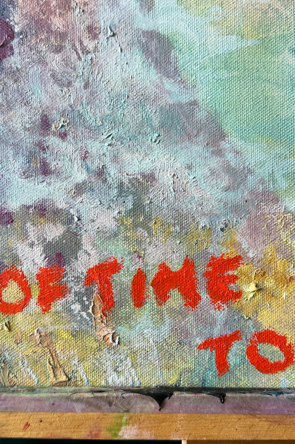 Text 'OF TIME TO' on a textured surface with abstract colors