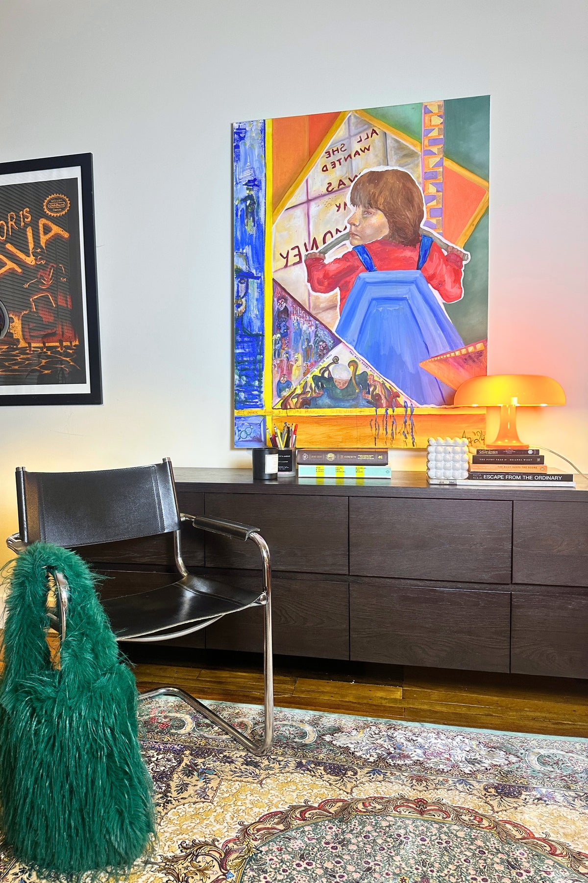 Living room with a large poster on the wall, a chair, and a lamp.
