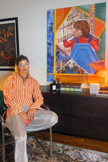 Person sitting in a room with a colorful painting on the wall