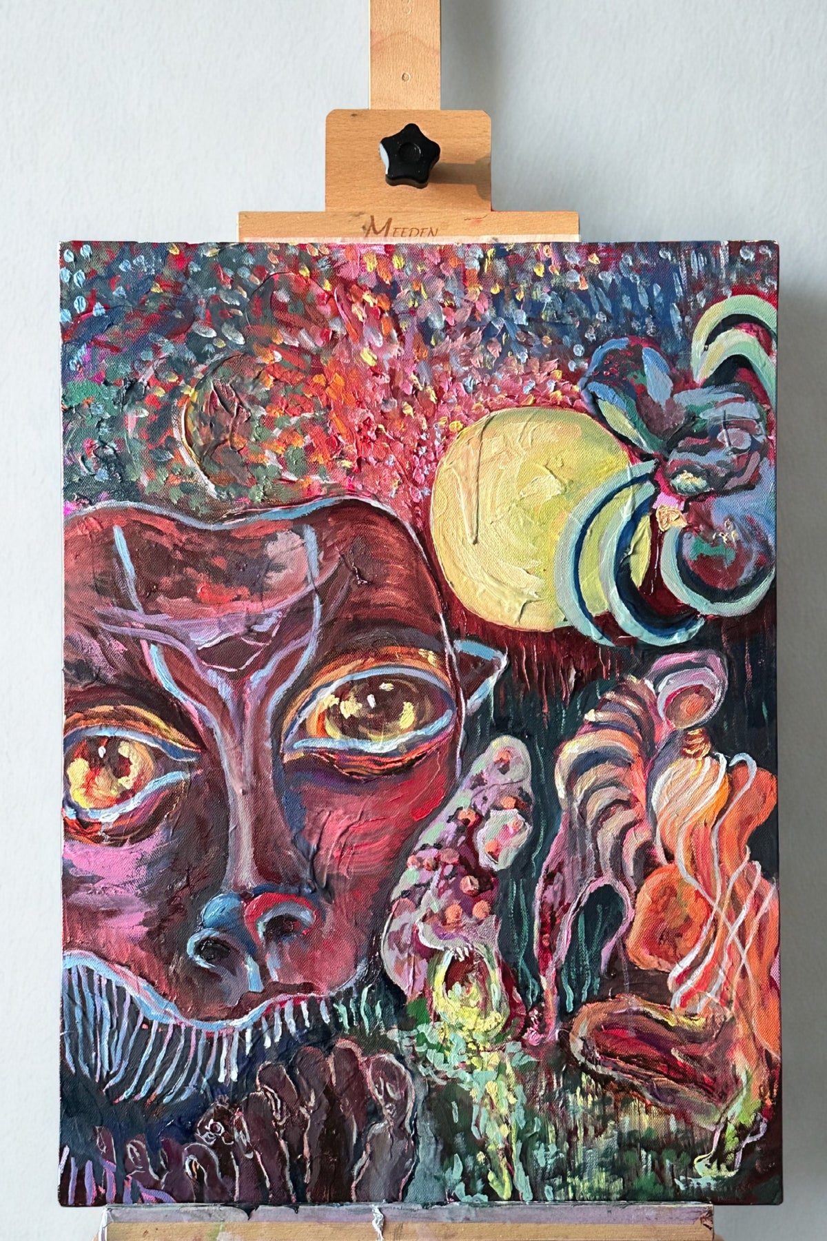 Colorful abstract painting on a canvas with a wooden easel.